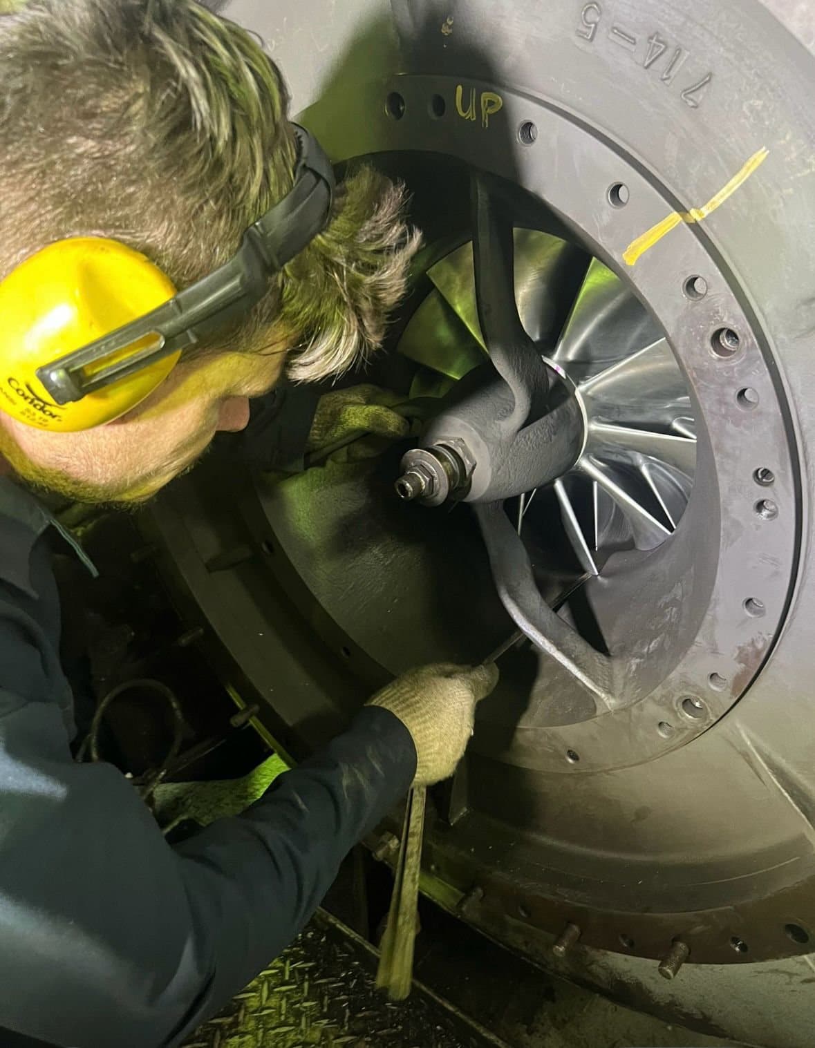 FG Turboservices engineer in ear defenders fitting a turbine rotor inside a turbocharger casing